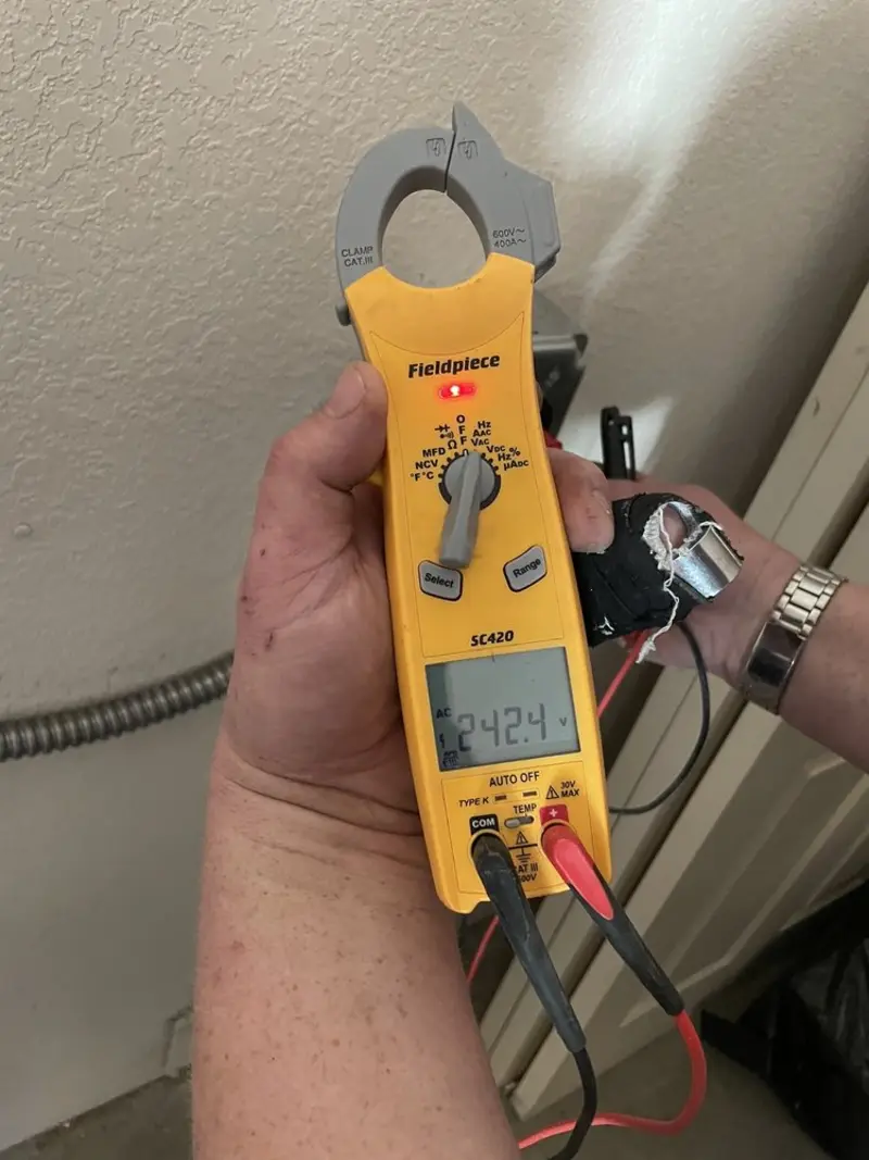 Voltage testing with clamp meter during Recessed Lighting Installation in Brown Station